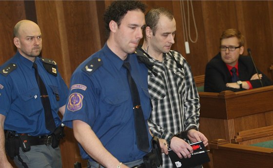Justiční stráž přivádí do soudní síně obžalovaného Tomáše Macka. (2. 4. 2014)