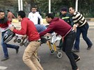 Kolemjdoucí civilisté pomáhají záchranái odvézt mue, jeho v Káhie zranil...