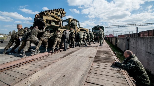 Ruští vojáci na Krymu nakládají ukrajinskou vojenskou techniku na vlak (8. dubna 2014)