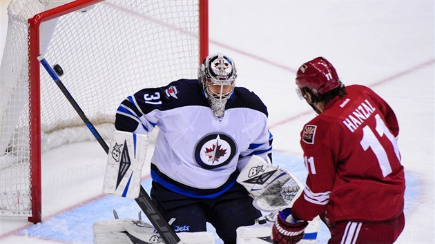 Brank Ondej Pavelec z Winnipegu likviduje anci Martina Hanzala z Phoenixu.