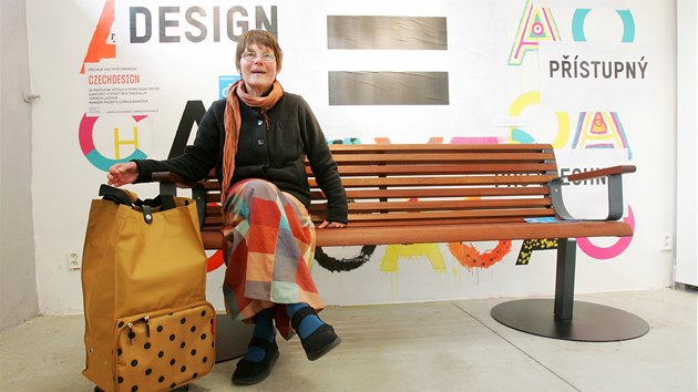 Na výstavě Equal design je k vidění také speciální ergonomická lavička pro seniory. Ideálně vysoká, s opěrátky a pohodlným sklonem sedací části. Sedí na ní Alena Samková, která má po ruce další vystavený výrobek - kabelku, která se dá rozložit na nákupní tašku.
