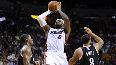 LeBron James z Miami st�ílí mezi Joem Johnsonem (vlevo) a Deronem Williamsem z