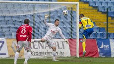 Pardubický gólman Lud�k Frydrych zasahuje proti hlavi�ce zlínského hrá�e.