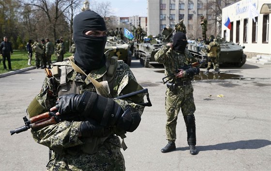 Neoznaení ozbrojenci v centru Slavjansku. Na jejich transportérech je vidt...