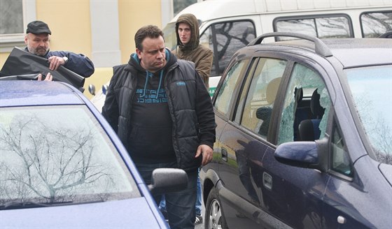 Policisté kontrolují automobily poničené při noční střelbě v Krnově.