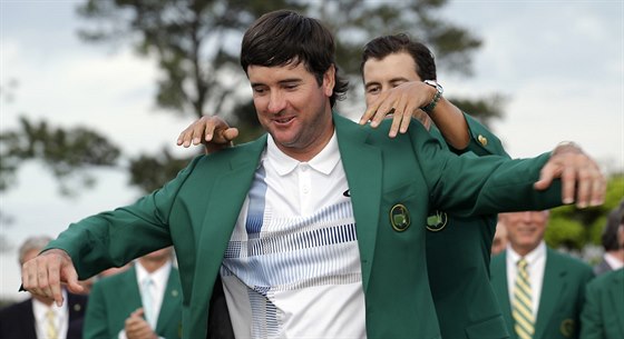 Loský ampion Adam Scott (vzadu) obléká do zeleného saka pro vítze golfového...