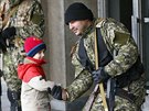 Proruský ozbrojenec v Slavjansku se zdraví s místním chlapcem (14. dubna 2014)