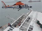 Záchranái pomáhají lidem na potápjícím se trajektu nedaleko pobeí...