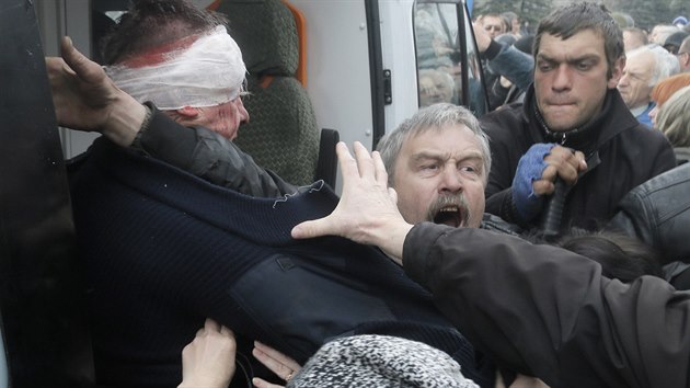 Mu se sna ochrnit policistu, kter piel k hon pi obran policejn stanice ve mst Horlivka (14. dubna 2014)