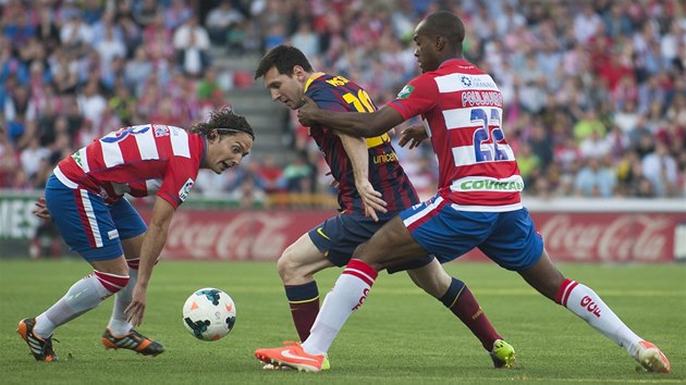 PROJDU TUDY? Lionel Messi z Barcelony se sna prosmknout mezi dvma brncmi hri Granady.