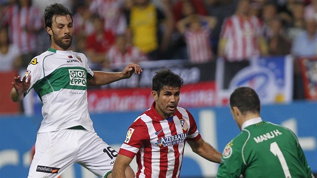 Diego Costa (uprosted) z Atltika Madrid pekonv branke Manu Herreru z Elche.