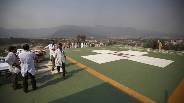 Lékaři na přistávací ploše nemocnice v Káthmándú očekávají vrtulník s raněnými, které zasypala lavina (18. 4. 2014)