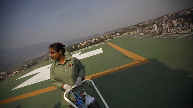 Lékaři na přistávací ploše nemocnice v Káthmándú očekávají vrtulník s raněnými, které zasypala lavina (18. 4. 2014)