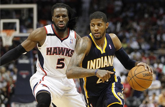 Paul George z Indiany utíká do útoku, nahání ho DeMarre Carroll z Atlanty.