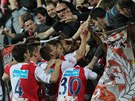 Fotbalisté Slavie se ze vsteleného gólu radují se svými fanouky.