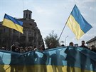 Stoupenci nové kyjevské vlády drí obí ukrajinskou vlajku na shromádní v...