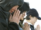 Píbuzní obtí z potopeného trajektu jihokorejské spolenosti Sewol se modlí v