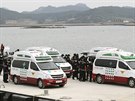 Vozy záchraná v jihokorejském pístavu Dindo nakládají tla pasaér, které...