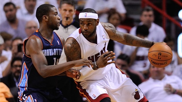 LeBron James (vpravo) se tla pes Michaela Kidda-Gilchrista z Charlotte.