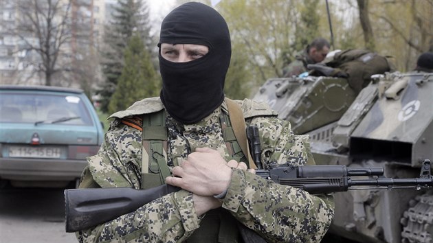 Maskovaný ozbrojený strážce s připnutou oranžovo-černou stuhou, která se stala symbolem proruské vzpoury na východě Ukrajiny.