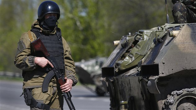 Příslušník ukrajinské armády hlídá kontrolní stanoviště u vesnice Malinovka, která je asi 20 kilometrů od Slavjansku na východě Ukrajiny (27. dubna 2014)