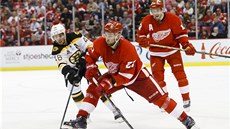 O puk bojují Kyle Quincey z Detroitu a David Krej�í z Bostonu (vlevo).