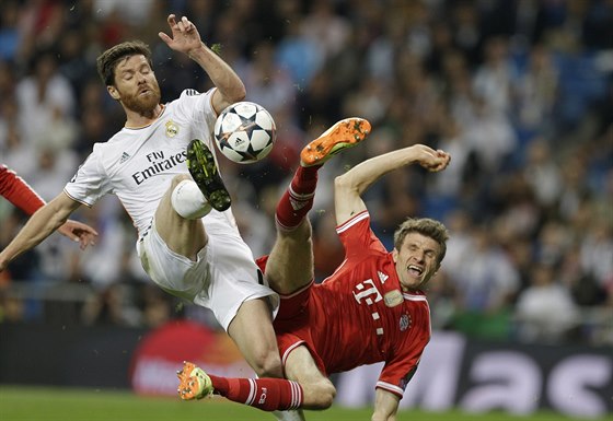 Xavi Alonso z Realu Madrid (vlevo) a Thomas Müller z Bayernu Mnichov bojují o...