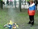 ena zahalená v ruských barvách sleduje pálení ukrajinských vlajek ped sídlem...