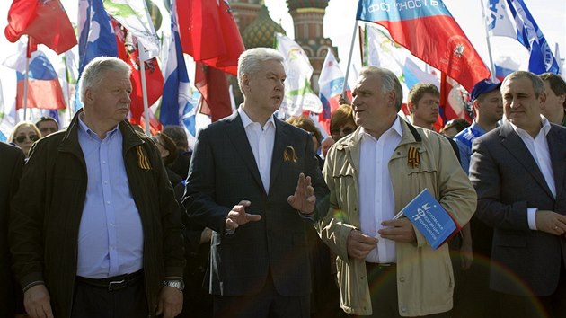 Moskevský starosta Moskvy Sergej Sobjanin mluví šéfem odborů Michailem Šmakovem. Odbory prvomájové oslavy na Rudém náměstí uspořádaly. (1. května 2014)