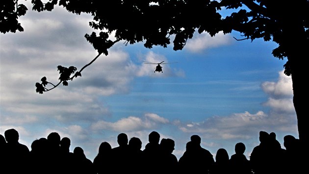 Účastníci vzpomínkového ceremoniálu přihlíží příletu helikoptéry s výsadkem.