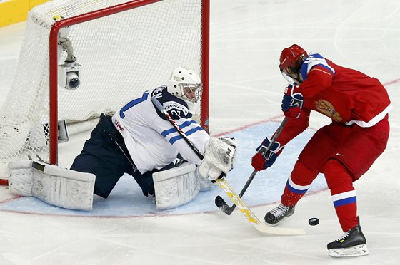 Finský gólman Mikko Kosikinen zasahuje proti Viktoru Tichonovovi z Ruska.