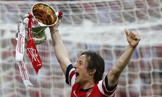 Záloník Arsenalu Tomá Rosický hrd nese trofej pro vítze FA Cupu.