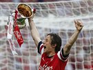Záloník Arsenalu Tomá Rosický hrd nese trofej pro vítze FA Cupu.