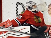 Brank Chicaga Corey Crawford hled v nepehledn situaci puk. 