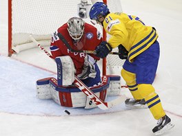 Norsk hokejov brank Steffen Soberg zasahuje proti Jimmie Ericssonovi ze