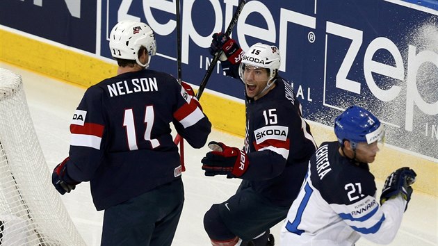 Americk hokejista Brock Nelson (vlevo) se raduje se spoluhrem Craigem Smithem z glu v duelu s Finskem. Fin Jori Lethera jen smutn projd kolem.
