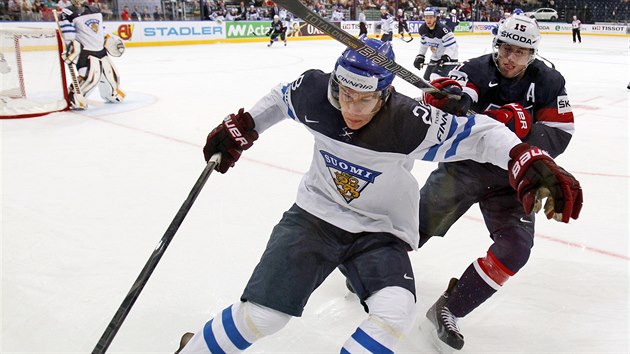 Finsk hokejista Jyri Marttinen (vlevo) si kryje puk ped americkm tonkem Craigem Smithem.