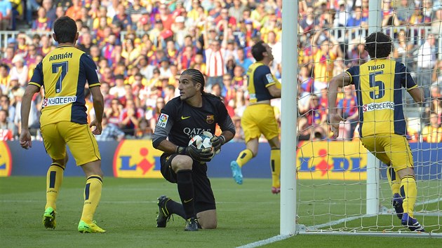 NA KOLENOU. Gólman Barcelony Jose Manuel Pinto (v černém) se smutně rozhlíží poté, co se prosadil Diego Godín z Atlética Madrid (v pozadí uprostřed).
