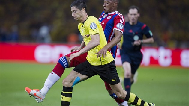 Robert Lewandowski z Dortmundu (ve lutm) postupuje dopedu, zastavit se ho sna Jerome Boateng z Bayernu Mnichov.