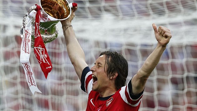 Záloník Arsenalu Tomá Rosický hrd nese trofej pro vítze FA Cupu.