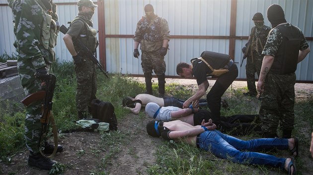 Prorut ozbrojenci zadreli ti mue, kter podezraj ze pione pro kyjevskou vldu (Kramatorsk, 18. kvtna 2014).
