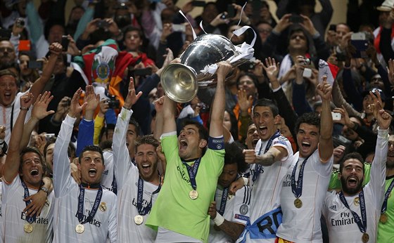 Fotbalisté Realu Madrid se radují z triumfu v Lize mistr. S pohárem nad hlavou...