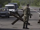 Proruský ozbrojenec stojí na silniním zátarasu nedaleko Slavjansku na trase do...