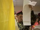 Ukrajinský voják zkoumá hlasovací lístek ve volební místnosti v Kyjev (25....