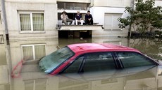 Mu�i sedí st�í�ce nad vchodem domu v zaplaveném bosenském m�st� Bosanski Samac....