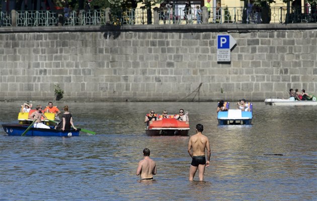 Dvojice mužů se ochlazuje ve Vltavě v centru Prahy, kde dnes panovalo tropické...