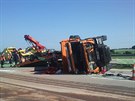Z pevráceného nákladního vozu spadl na dálnici D11 bagr a zablokoval provoz....