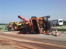 Z pevráceného nákladního vozu spadl na dálnici D11 bagr a zablokoval provoz....