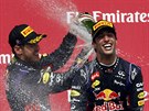 DEN PRO RED BULL. Sebastian Vettel poutí umivé víno za krk Daniela Ricciarda,...