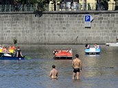 Dvojice mužů se ochlazuje ve Vltavě v centru Prahy, kde dnes panovalo tropické...